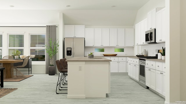 4204 Hampshire Way, San Antonio, TX 78245 - kitchen featuring stainless steel microwave, range with gas stovetop, refrigerator with ice dispenser, a sink, and a kitchen island
