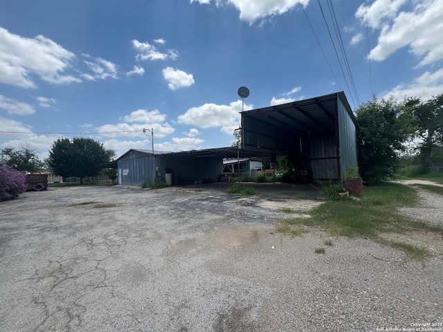 413 4th St, Poteet, TX 78065 - view of outbuilding with asphalt driveway and a carport