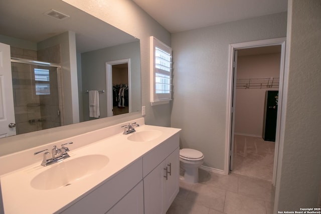 10322 Lady Bird, San Antonio, TX 78252 - bathroom with a spacious closet, double vanity, a stall shower, a textured wall, and tile patterned flooring