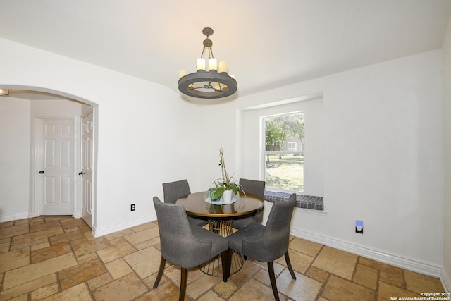13607 Stagecoach, San Antonio, TX 78253 - dining room featuring stone tile flooring, arched walkways, a chandelier, and baseboards