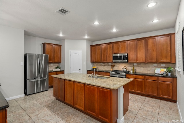 116 Cold Riv, Boerne, TX 78006 - kitchen featuring appliances with stainless steel finishes, decorative backsplash, recessed lighting, an island with sink, and brown cabinetry