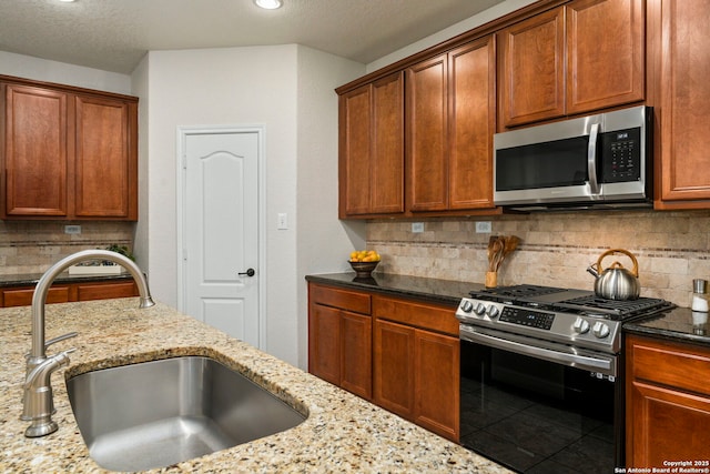 116 Cold Riv, Boerne, TX 78006 - kitchen with appliances with stainless steel finishes, light stone counters, backsplash, brown cabinetry, and recessed lighting
