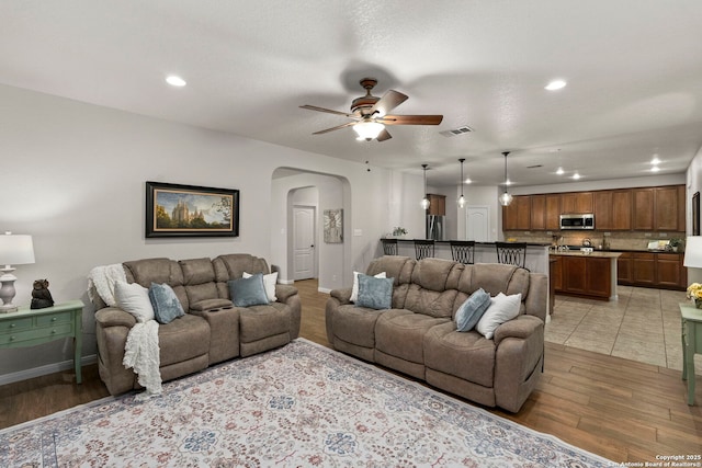 116 Cold Riv, Boerne, TX 78006 - living room featuring arched walkways, ceiling fan, light wood-type flooring, and recessed lighting