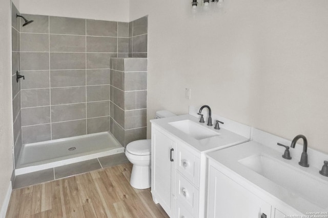 2402 W Martin St, San Antonio, TX 78207 - full bathroom featuring vanity, tiled shower, and wood finished floors
