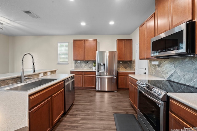 220 Hinge, Cibolo, TX 78108 - kitchen with appliances with stainless steel finishes, dark wood-type flooring, backsplash, light countertops, and brown cabinets