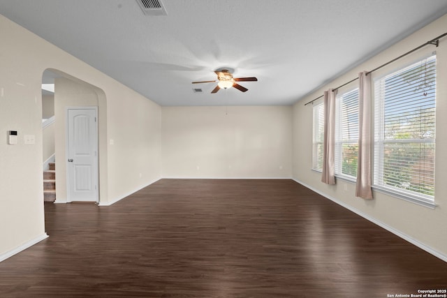 220 Hinge, Cibolo, TX 78108 - spare room featuring a ceiling fan, dark wood-type flooring, stairs, and arched walkways