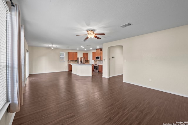220 Hinge, Cibolo, TX 78108 - unfurnished living room with arched walkways, a ceiling fan, dark wood-style flooring, and recessed lighting