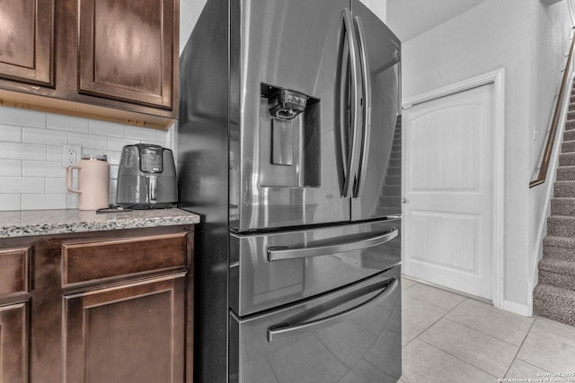 8919 Ladbroke, Converse, TX 78109 - kitchen with stainless steel refrigerator with ice dispenser, backsplash, light tile patterned floors, light stone countertops, and dark brown cabinets