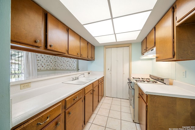 7022 Centergrove Dr, San Antonio, TX 78227 - kitchen with white range with gas stovetop, under cabinet range hood, light countertops, and brown cabinetry