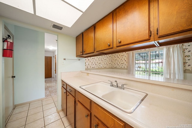 7022 Centergrove Dr, San Antonio, TX 78227 - kitchen featuring brown cabinetry, light countertops, and light tile patterned floors