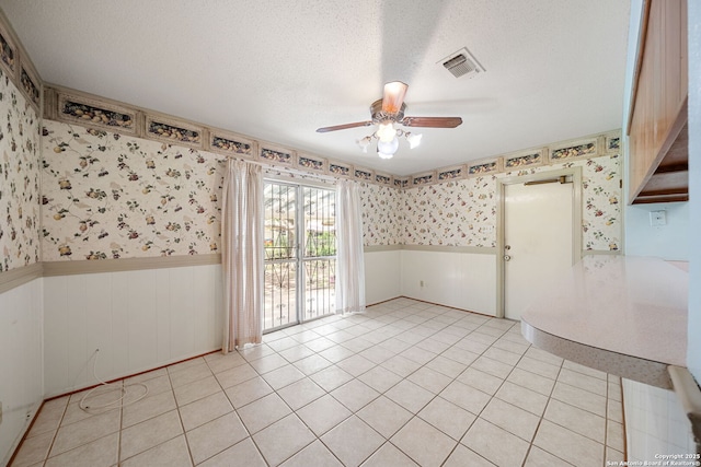 7022 Centergrove Dr, San Antonio, TX 78227 - empty room with a wainscoted wall, wallpapered walls, ceiling fan, a textured ceiling, and light tile patterned floors
