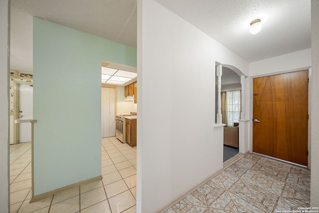 7022 Centergrove Dr, San Antonio, TX 78227 - hallway with arched walkways, light tile patterned floors, and a textured ceiling