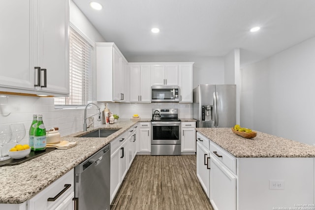 336 Salz, San Antonio, TX 78260 - kitchen with stainless steel appliances, a kitchen island, white cabinetry, wood finished floors, and backsplash