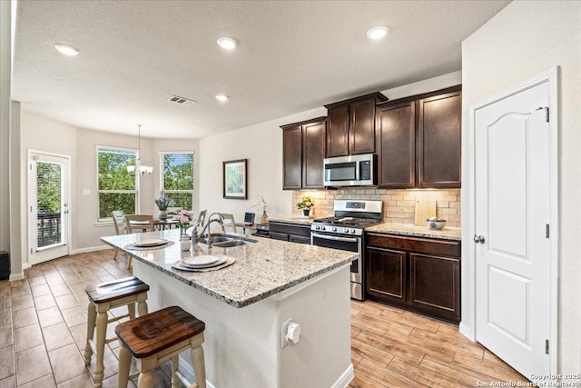 16327 Amistad Pass, San Antonio, TX 78247 - kitchen featuring appliances with stainless steel finishes, light stone counters, decorative backsplash, a breakfast bar, and dark brown cabinets