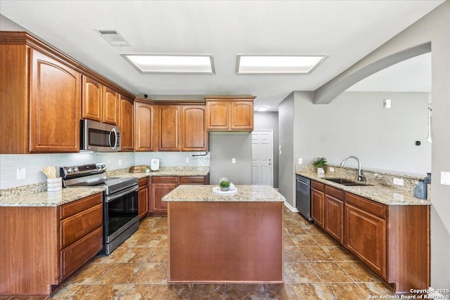 3607 Mill Mdw, San Antonio, TX 78247 - kitchen featuring appliances with stainless steel finishes, arched walkways, backsplash, and light stone countertops
