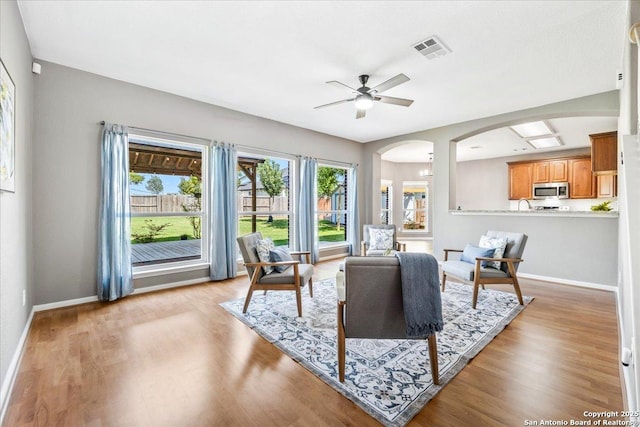 3607 Mill Mdw, San Antonio, TX 78247 - living room with arched walkways, light wood-style floors, and ceiling fan
