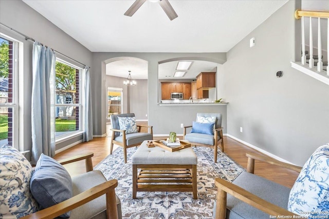 3607 Mill Mdw, San Antonio, TX 78247 - living area with arched walkways, light wood finished floors, ceiling fan, and a chandelier