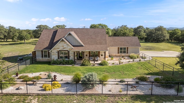 744 E Rio Azule, Pipe Creek, TX 78063 - view of front facade with stone siding, a fenced backyard, a porch, and a shingled roof