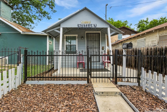 1105 Delgado St, San Antonio, TX 78207 - view of front of home with covered porch, a gate, and a fenced front yard