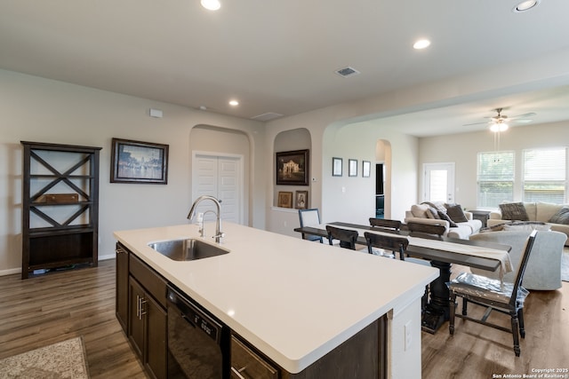 129 Thurston, Bastrop, TX 78602 - kitchen with black dishwasher, arched walkways, light countertops, dark wood-style floors, and recessed lighting