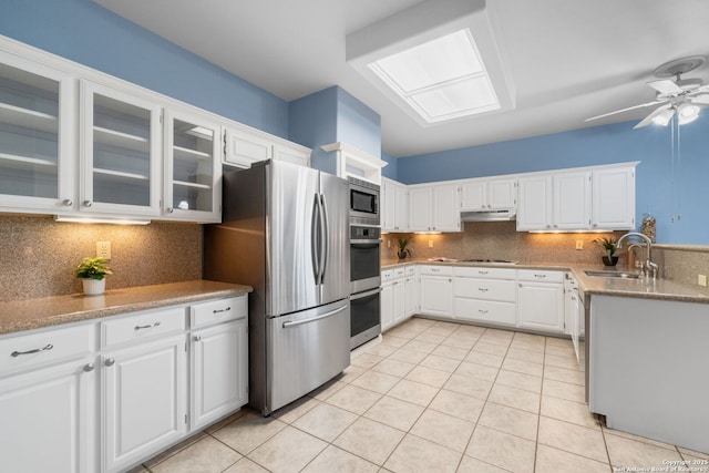 2430 Burning Trl, San Antonio, TX 78232 - kitchen featuring appliances with stainless steel finishes, under cabinet range hood, light tile patterned flooring, backsplash, and glass insert cabinets