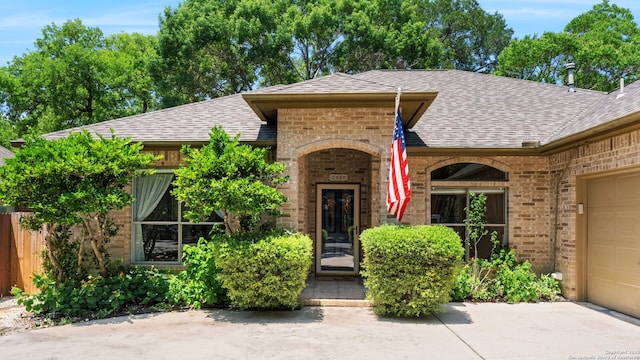 2430 Burning Trl, San Antonio, TX 78232 - view of front facade with a shingled roof, brick siding, and a garage