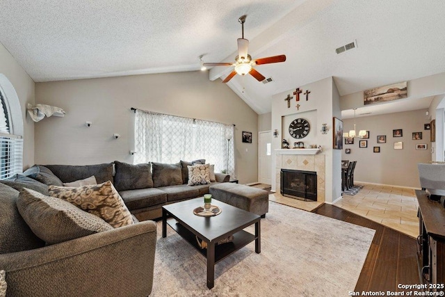 6411 Gray Rdg, San Antonio, TX 78233 - living room with ceiling fan, lofted ceiling, wood finished floors, a fireplace, and a textured ceiling