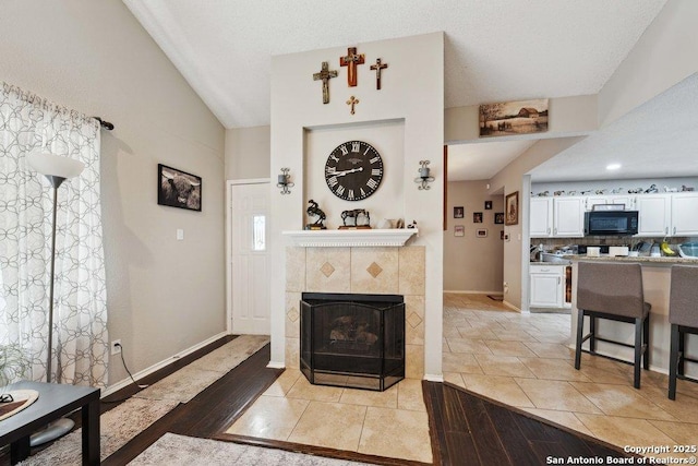 6411 Gray Rdg, San Antonio, TX 78233 - living room with lofted ceiling, a tile fireplace, and light wood-style flooring
