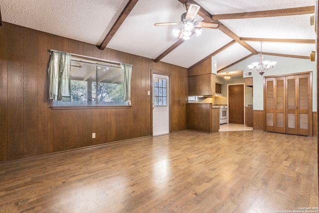 6618 N Forest Bnd, San Antonio, TX 78240 - unfurnished living room featuring wood finished floors, wood walls, a ceiling fan, a chandelier, and a textured ceiling