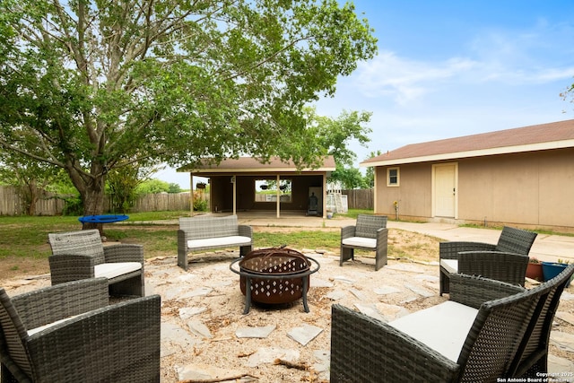 1373 County Road 373, Uvalde, TX 78801 - fenced backyard featuring a fire pit, a patio, and an outbuilding