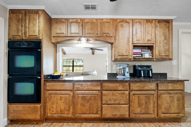 1373 County Road 373, Uvalde, TX 78801 - kitchen featuring dark stone countertops, ceiling fan, brown cabinetry, and crown molding