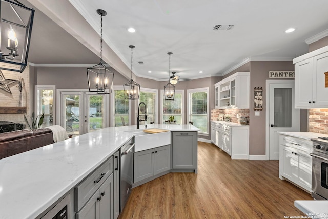 608 Kendall Pkwy, Boerne, TX 78015 - kitchen with light wood-style flooring, recessed lighting, white cabinetry, gray cabinetry, and glass insert cabinets