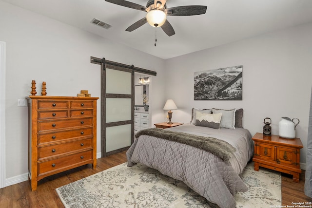 608 Kendall Pkwy, Boerne, TX 78015 - bedroom featuring a barn door, wood finished floors, and a ceiling fan