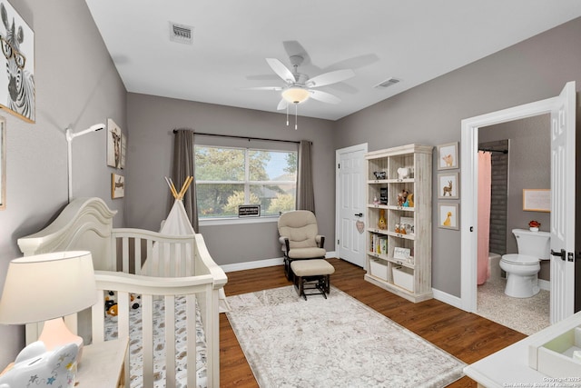 608 Kendall Pkwy, Boerne, TX 78015 - bedroom with dark wood-style flooring, a nursery area, ceiling fan, and connected bathroom