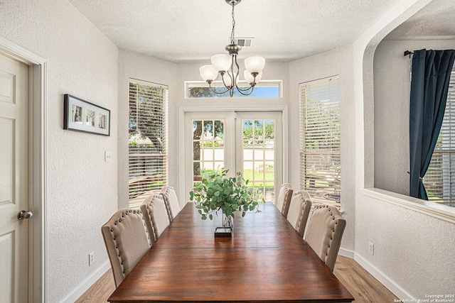 13812 Riverbank Pass, Helotes, TX 78023 - dining room with a textured wall, a chandelier, wood finished floors, and a textured ceiling