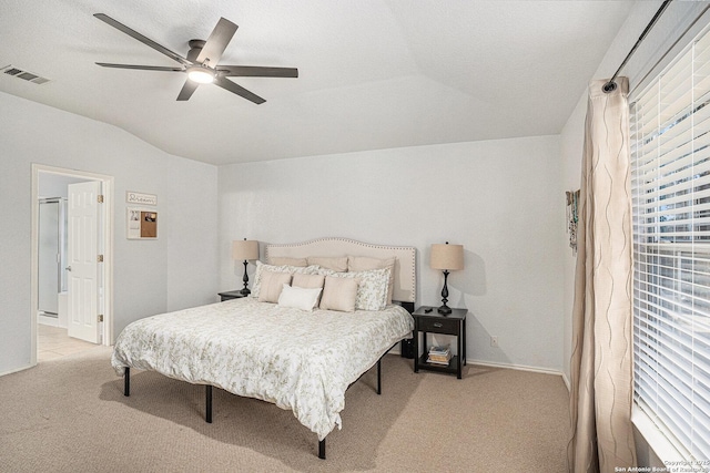 13812 Riverbank Pass, Helotes, TX 78023 - bedroom with light colored carpet, vaulted ceiling, multiple windows, ceiling fan, and ensuite bathroom