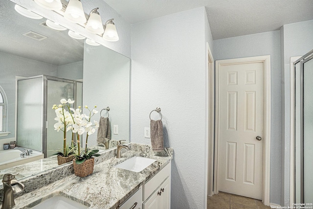 13812 Riverbank Pass, Helotes, TX 78023 - bathroom featuring a stall shower, double vanity, a chandelier, tile patterned flooring, and a textured wall