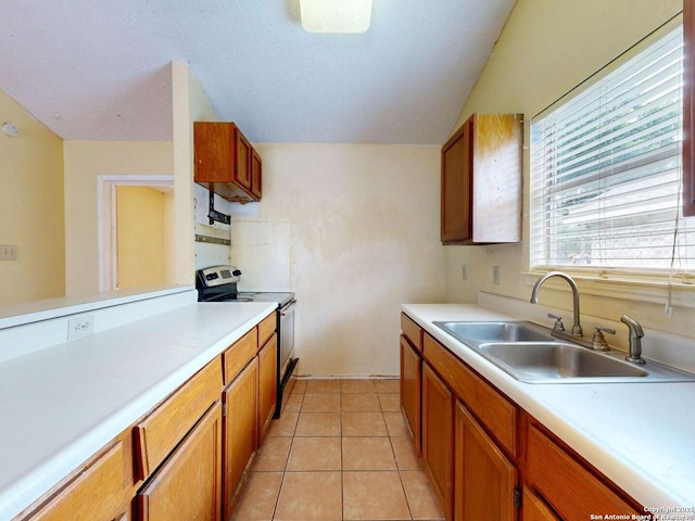 3415 Twining, San Antonio, TX 78211 - kitchen featuring electric range, light countertops, brown cabinetry, and lofted ceiling