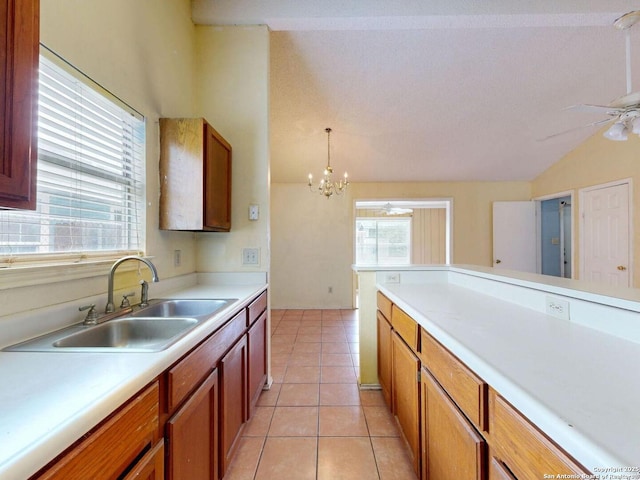 3415 Twining, San Antonio, TX 78211 - kitchen featuring light countertops, lofted ceiling, brown cabinetry, light tile patterned flooring, and a chandelier