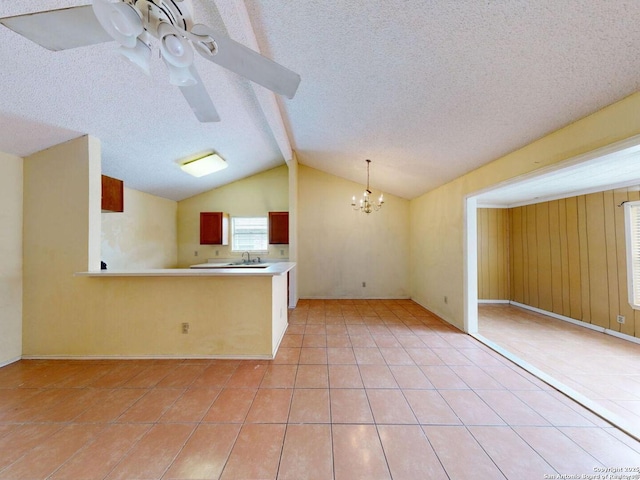 3415 Twining, San Antonio, TX 78211 - kitchen featuring light tile patterned floors, a chandelier, a textured ceiling, vaulted ceiling, and light countertops