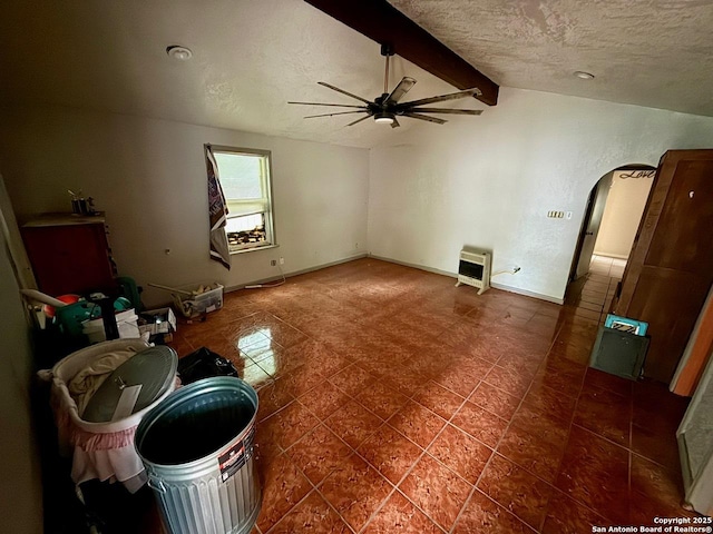 215 W Academy, San Antonio, TX 78226 - unfurnished living room with ceiling fan, a textured ceiling, arched walkways, heating unit, and tile patterned flooring