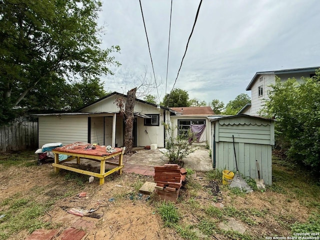 215 W Academy, San Antonio, TX 78226 - back of property featuring a storage unit and a patio