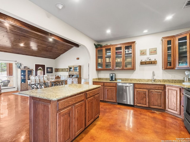 1131 Meadow Stream Rd, Spring Branch, TX 78070 - kitchen featuring appliances with stainless steel finishes, concrete flooring, lofted ceiling, arched walkways, and brown cabinets