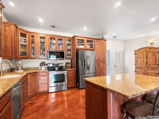 1131 Meadow Stream Rd, Spring Branch, TX 78070 - kitchen with stainless steel appliances, concrete flooring, a kitchen bar, recessed lighting, and glass insert cabinets