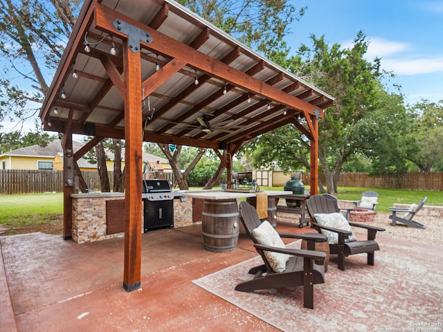 1131 Meadow Stream Rd, Spring Branch, TX 78070 - fenced backyard featuring a fire pit, a patio, ceiling fan, and exterior kitchen