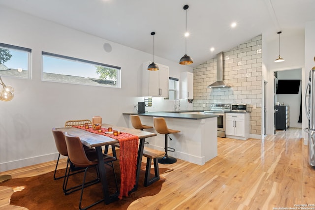 1442 Bob White, Spring Branch, TX 78070 - kitchen with wall chimney range hood, appliances with stainless steel finishes, white cabinetry, light wood-type flooring, and tasteful backsplash