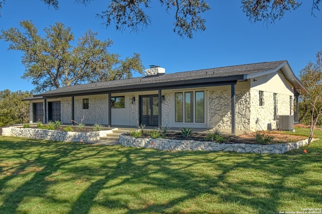 304 Crestwood Dr, Kingsland, TX 78639 - rear view of house with stone siding, a lawn, and a chimney