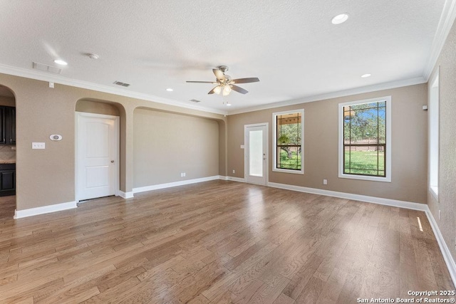 120 Red Bud, Boerne, TX 78006 - unfurnished room with arched walkways, a ceiling fan, light wood-style floors, crown molding, and a textured ceiling