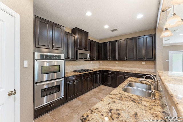 120 Red Bud, Boerne, TX 78006 - kitchen with stainless steel appliances, backsplash, light stone countertops, decorative light fixtures, and recessed lighting
