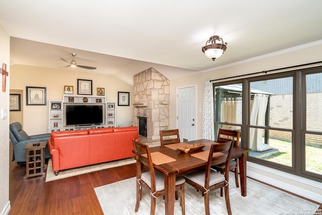 10707 Lake Path, San Antonio, TX 78217 - dining area featuring wood finished floors, a stone fireplace, a ceiling fan, crown molding, and vaulted ceiling
